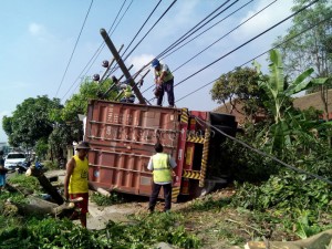 truk terguling timpa rumah dan mobil 1