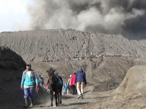 Sehari menjelang puncak perayaan Yadnya Kasada, wisatawan dari berbagai daerah terus berdatangan di Gunung Bromo, Selasa (19/07/2016). Antisipasi bahaya,  petugas terus menghimbau agar pengunjung tak mendekati zona bahaya kawah di radius 1 kilometer. Meski demikian masih banyak wisatawan yang nekat naik ke kawah untuk menyaksikan kawah yang tengah mengeluarkan asap pekat dari dekat. (Foto: Sundari/wartabromo.com)