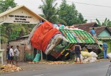 Truk Muat Kapuk Sasak Gapura dan Rumah Warga