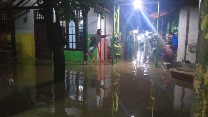 Sejumlah warga Jl Diponegoro, Kota Pasuruan terlihat memantau air banjir yang menerjang dengan ketinggian lebih satu meter, Kamis (17/1/2019) sejak sore hingga malam hari ini.