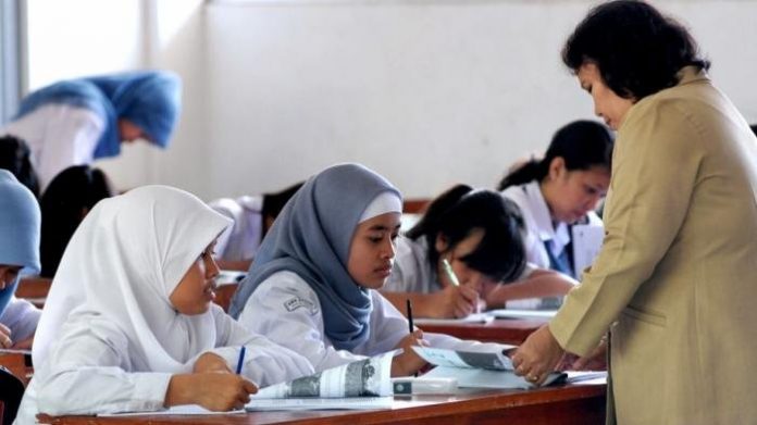 Seorang guru tengah mengajar di dalam kelas sebuah sekolah di Kabupaten Pasuruan. (Foto: ilustrasi/dokumen)