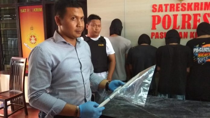 Kasat Reskrim Polres Pasuruan Kota, AKP Slamet Santoso menunjukkan barang bukti pengeroyokan yang sebabkan seorang remaja tewas.