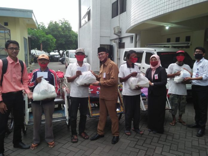 BERBAGI: Pimpinan Bank Jatim Pasuruan, Deddy Ajie Wijaya (enpat dari kiri) menyalurkan bantuan pada tukang becak diikuti oleh para karyawan Bank Jatim lainnya.