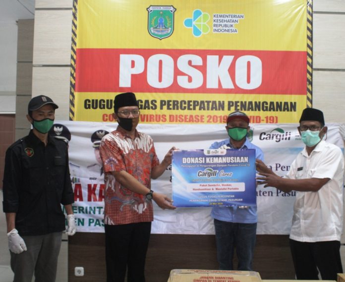 DONASI.KEMANUSIAAN: Perwakilan Cargill memberikan bantuan kemanusiaan kepada pemerintah Kabupaten Pasuruan yang diterima wakil ketua Satgas, Sudiono Fauzan dan wakil sekretaris satgas, Anang Saiful Wijaya.