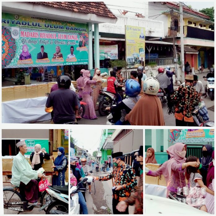 BAGI TAKJIL DAN MASKER: Para Kepala Madrasah dan guru di Lembaga Riyadlul Ulum Bangil saat membagikan takjil dan masker gratis di depan lembaganya, Jumat (22/5) kemarin.