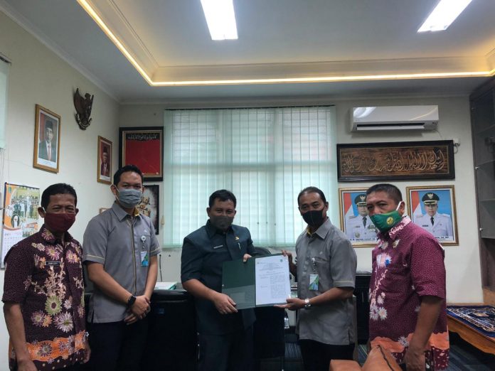 PERJANJIAN KERJASAMA: Kepala Dinas Pendidikan Kabupaten Pasuruan, Akhmad Khasani (tiga dari kiri) menunjukkan perjanjian kerjasama untuk perlindungan guru dengan Kepala Kantor BP Jamsostek, Arie Fianto Syofian di kantor Diknas, Komplek Perkantoran Raci - Bangil.