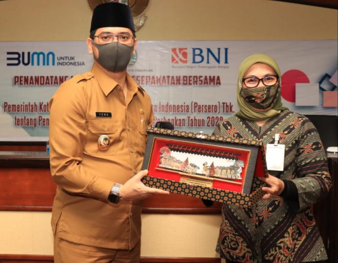 CENDERA MATA: Head Of Region BNI Wilayah Malang, Beby Lolita Indriani menerima cendera mata dari Plt Walikota Pasuruan, Raharto Teno Prasetyo usai penandatanganan kesepakatan, Selasa (15/9).