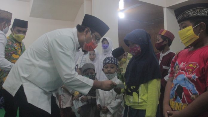 SANTUNAN: Gus Ipul bersama Adi Wibowo dan ketua tim pemenangan, H Junaidi memberikan santunan kepada anak yatim saat pembukaan posko, Selasa malam (22/9).