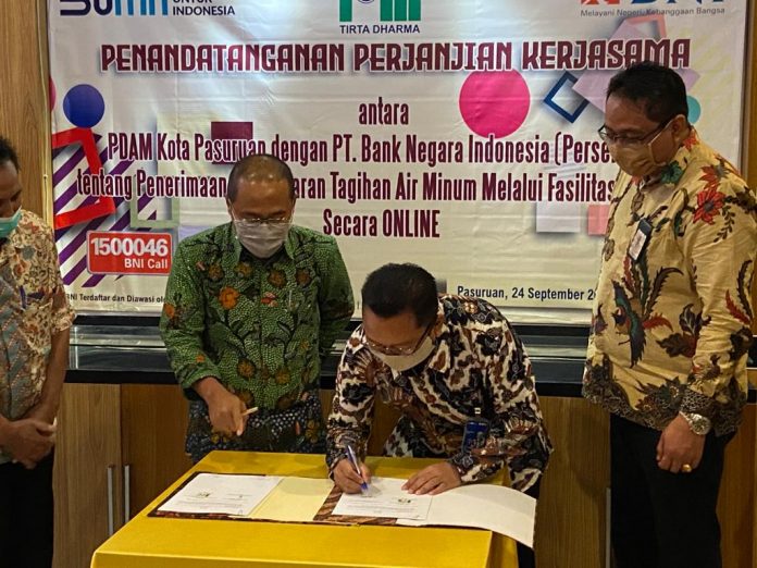 PENANDATANGANAN: Pimpinan Cabang BNI 46 Pasuruan, Rinto Indra Irawan menandatangani Perjanjian Kerjasama dengan PDAM Tirta Kota Pasuruan disaksikan Direktur PDAM, Robert Balbut (kiri) dan Doni Suseno M,Pemimpin Bidang Bisnis BNI Pasuruan.