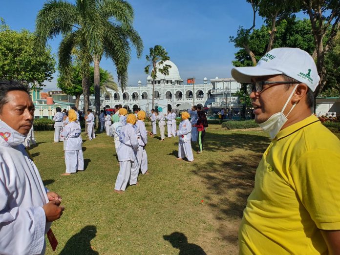 SALING SAPA: Adi Wibowo (kanan) secara tak sengaja bertemu komunitas olahraga pencak silat Perisai Diri di Alun-Alun Kota Pasuruan, Minggu pagi (4/10).