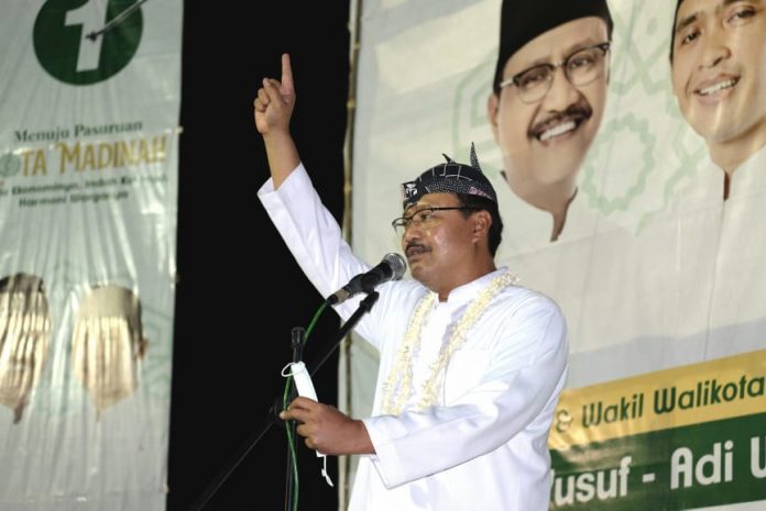 SEMANGAT: Gus Ipul tampil mengenakan blankon saat menyapa warga Darmoyudo Kelurahan Purworejo, Sabtu malam (17/10).