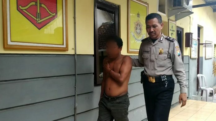 Faisol digelandang petugas menuju ruang penyidik di Mapolsek Purworejo, Kota Pasuruan, Rabu (2/1/2018).