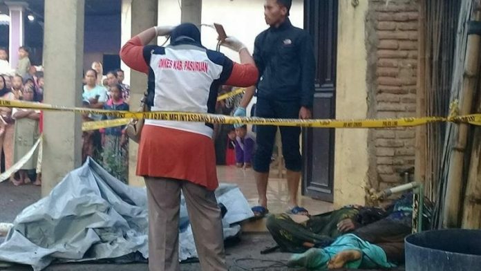 Polisi saat olah TKP di sisi rumah Dhofir. Di tempat ini,. ditemukan dua orang tewas dengan kondisi tubuh terbakar, Minggu (20/1/2019). (Foto: istimewa).