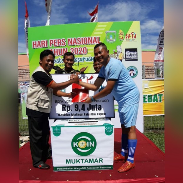 SUMBANG MUKTAMAR NU: Pimpinan Bank Jatim Pasuruan, Deddy Ajie (kanan) menyerahkan sumbangan koin muktamar NU saat hari pers di Stadion Pogar, Sabtu (8/2).