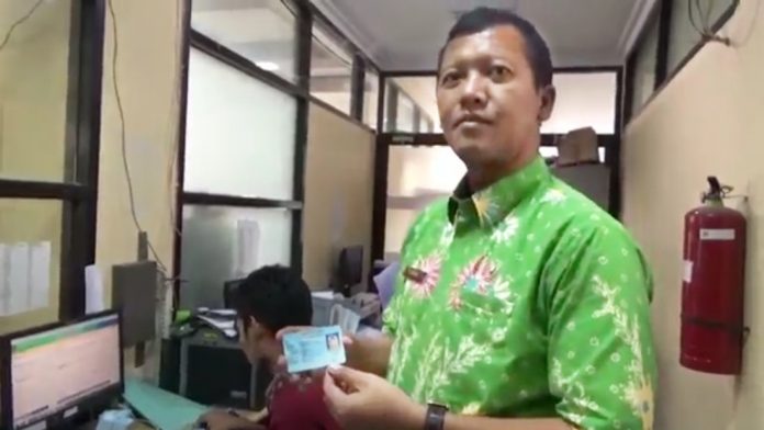 Yudha Triwidya Sasongko, Kepala Dispendukcapil Kabupaten Pasuruan, menunjukkan KTP-el milik warga yang telah tercetak.