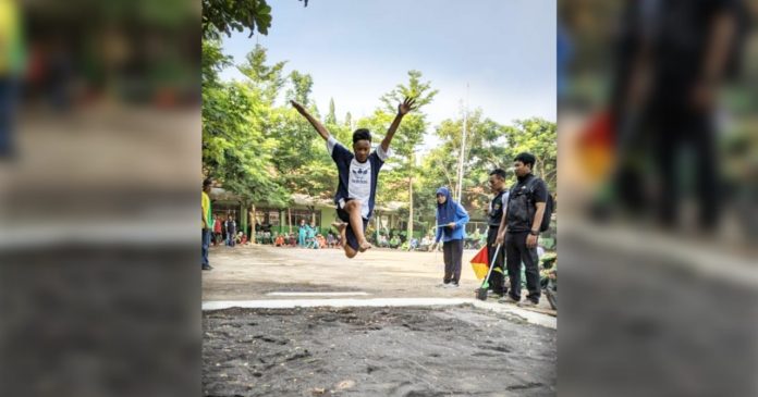 LOMPAT JAUH: Salah satu peserta seleksi POPDA Cabor atletik lompat jauh saat beraksi di lapangan SMPN 1 Bangil.